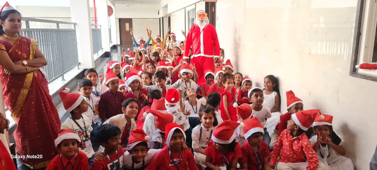 Students in Santa hats with Santa Claus at the Christmas celebration, Takshashila School @ Rampura