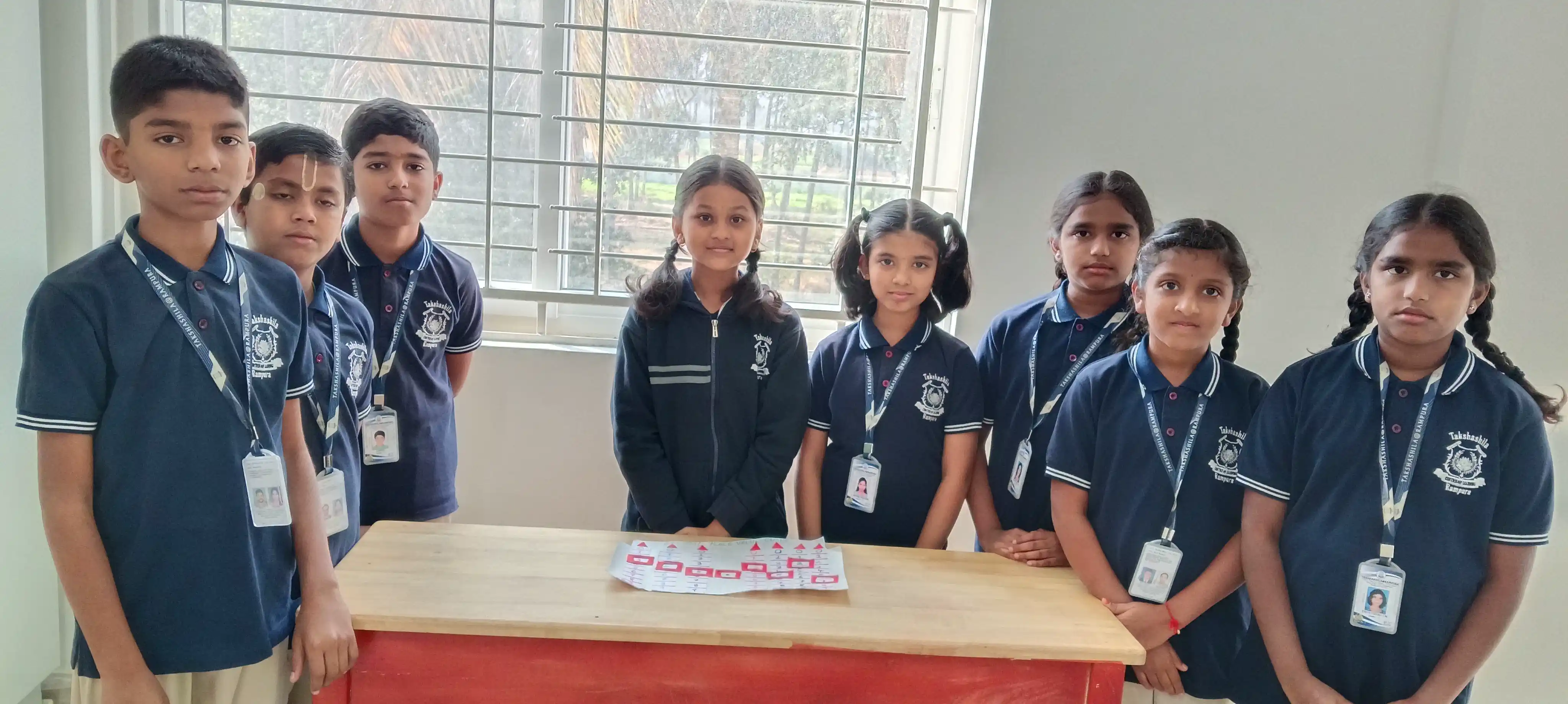 Primary students in Takshashila School uniforms presenting their class project