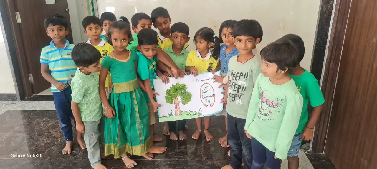 Pre-school children holding up their tree drawing at Takshashila School