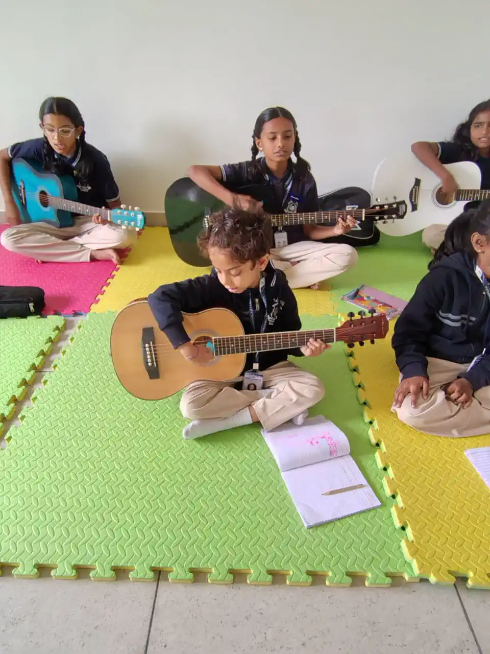 Students learning to play the guitar at Takshashila School @ Rampura