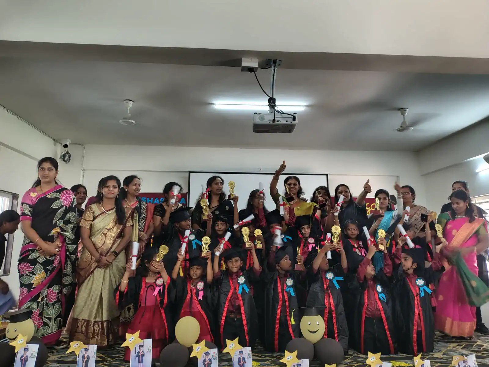 Students in graduation gowns celebrating with their teachers at Takshashila School @ Rampura