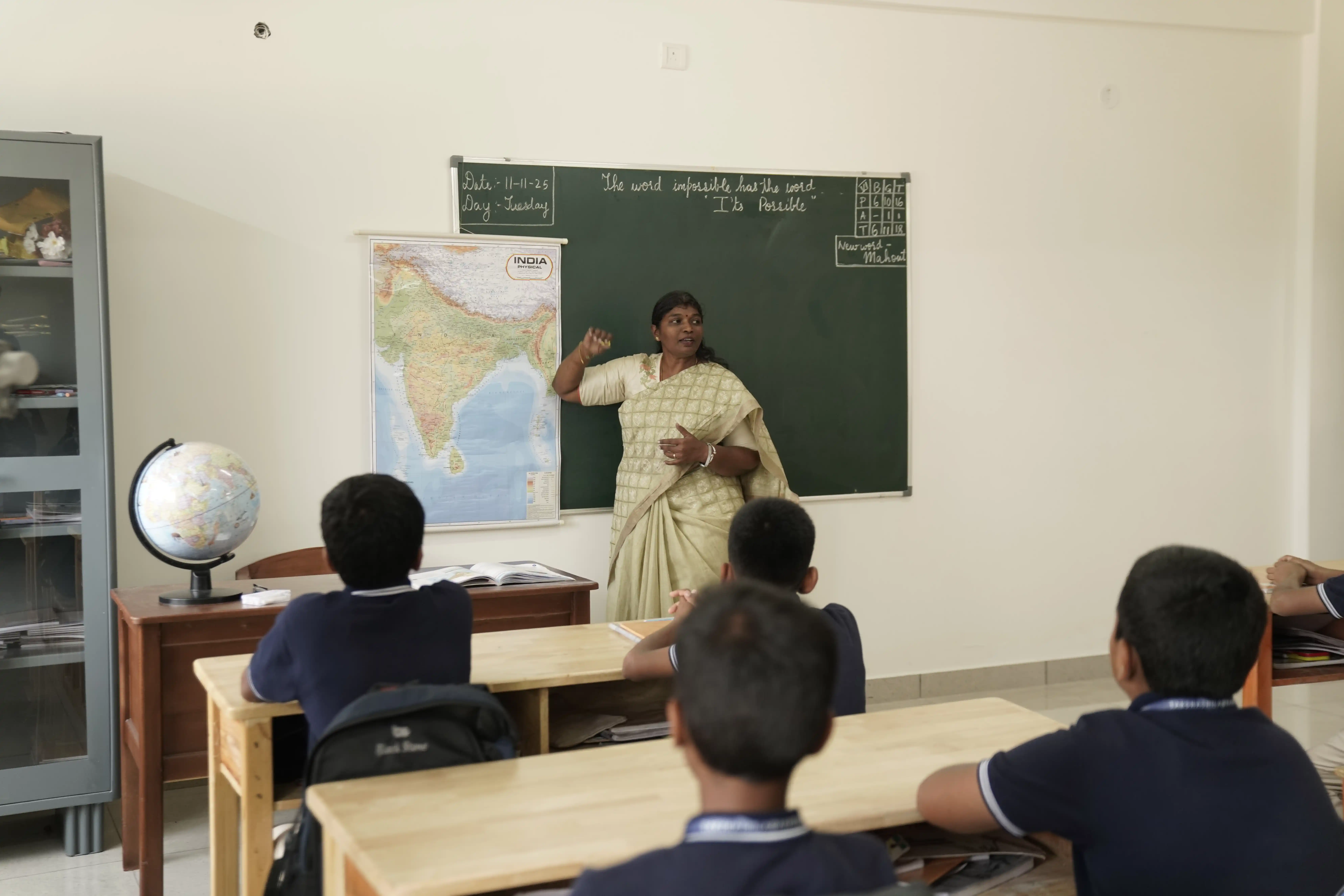 Teacher taking a class with a map and blackboard at Takshashila School @ Rampura
