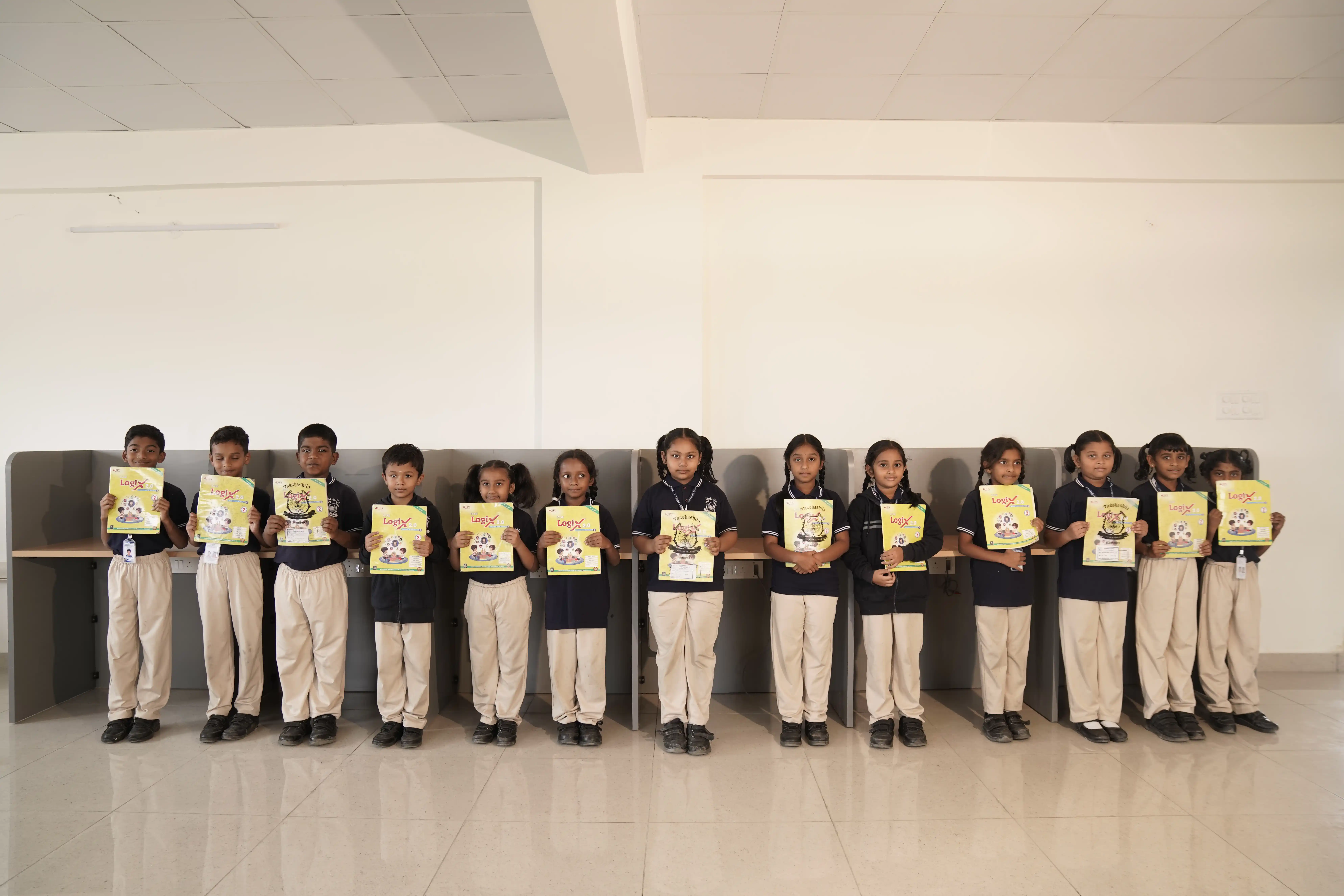 Students lined up holding their certificates at Takshashila School