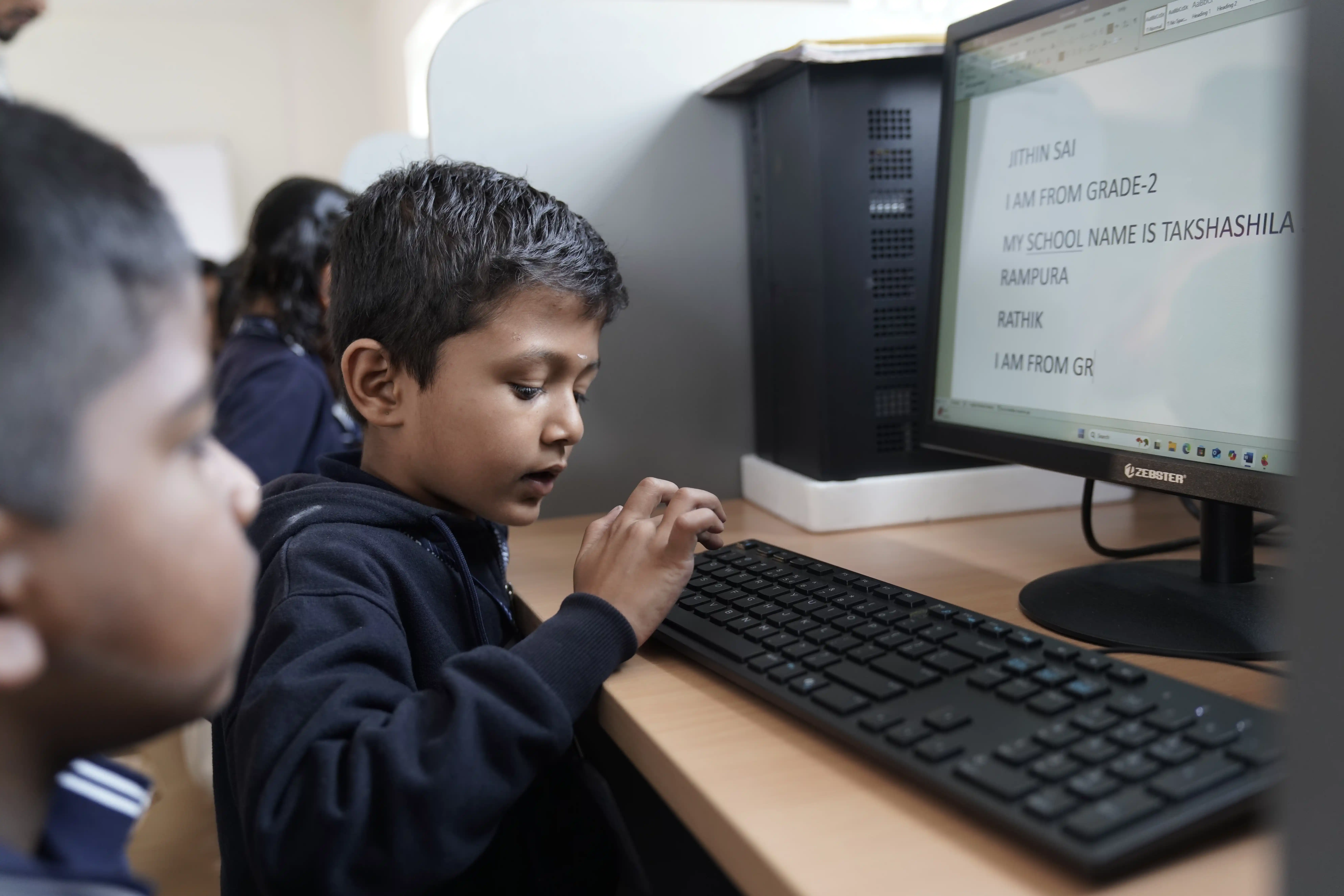 Student working on a computer in the computer lab at Takshashila School @ Rampura