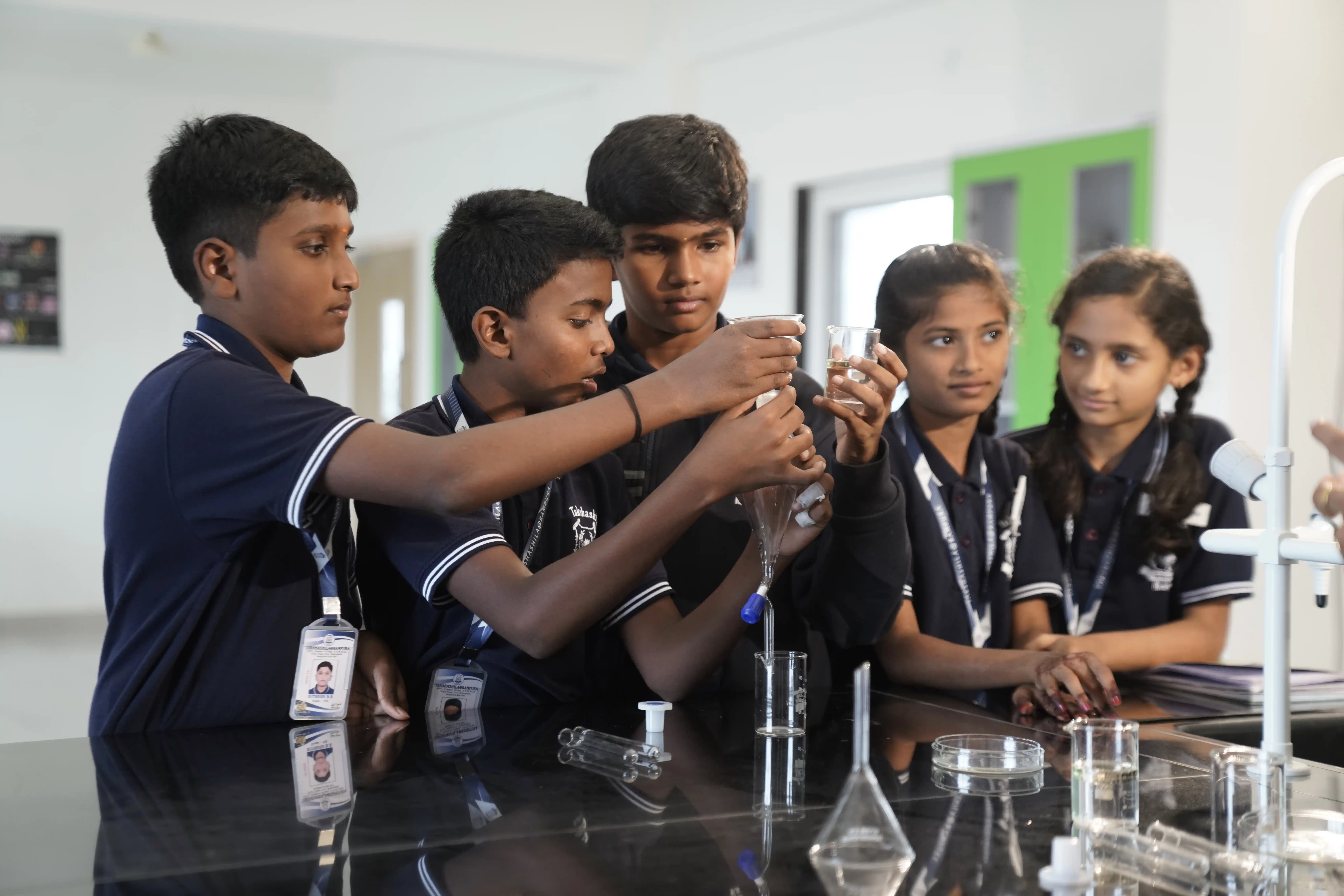 Students doing a chemistry experiment in the science lab at Takshashila School @ Rampura