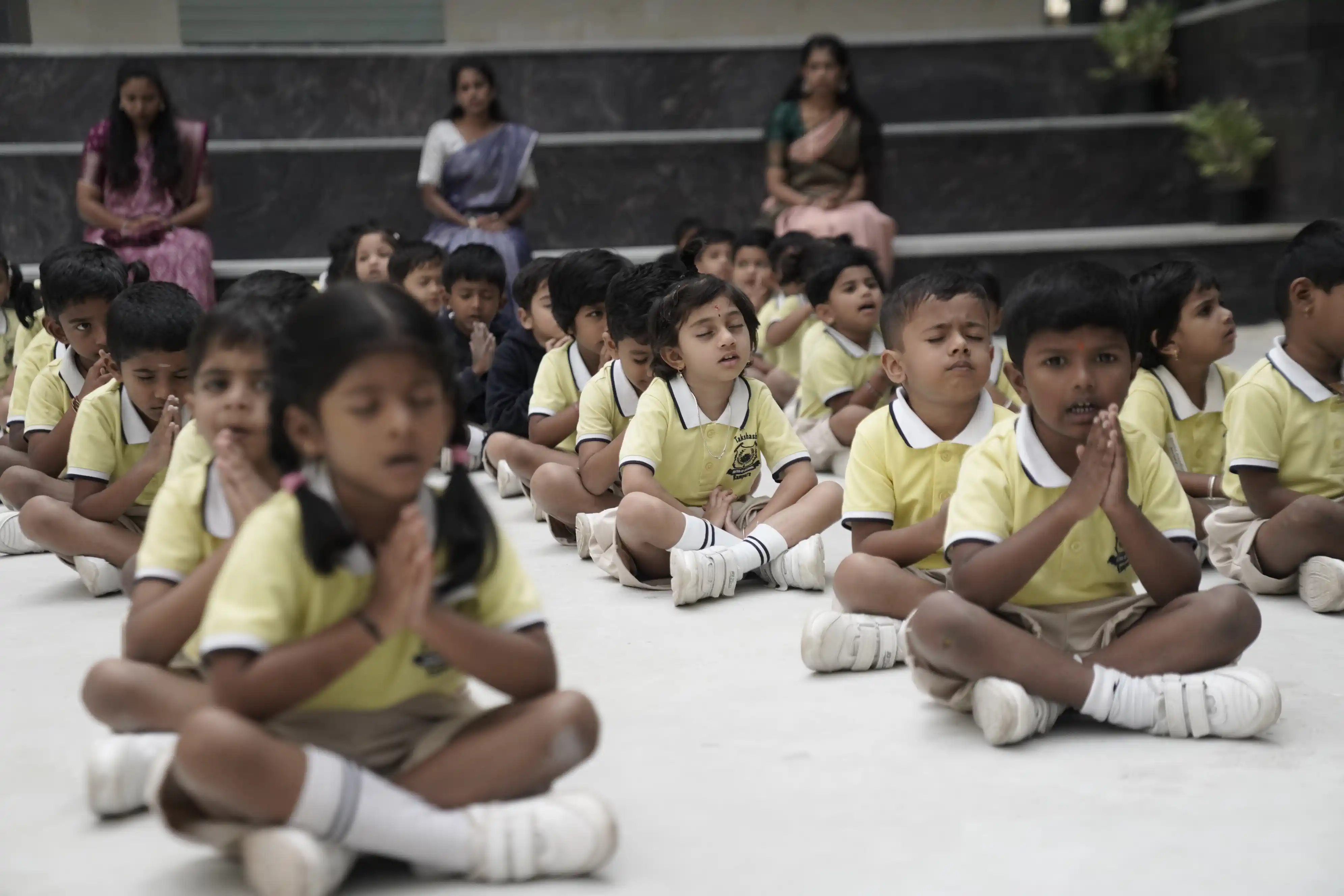 Pre-school children meditating with folded hands at Takshashila School