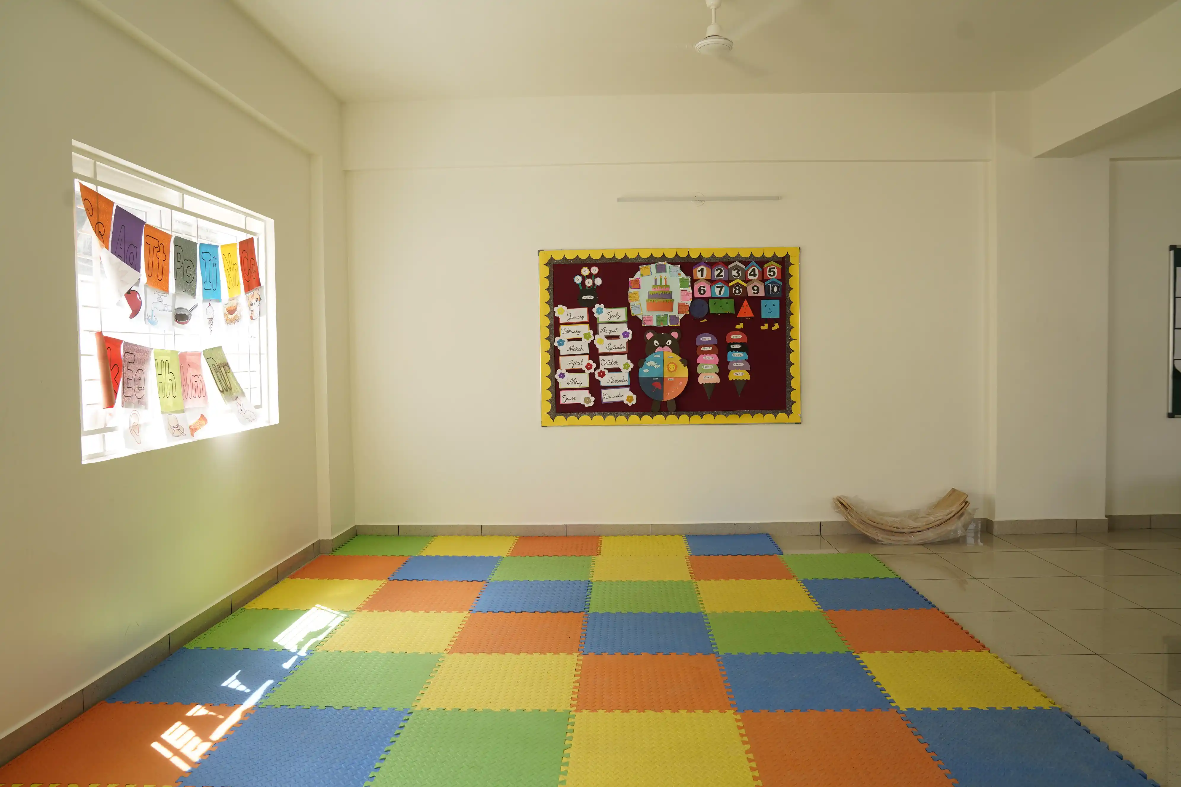 Indoor activity room with colourful floor mats at Takshashila School @ Rampura