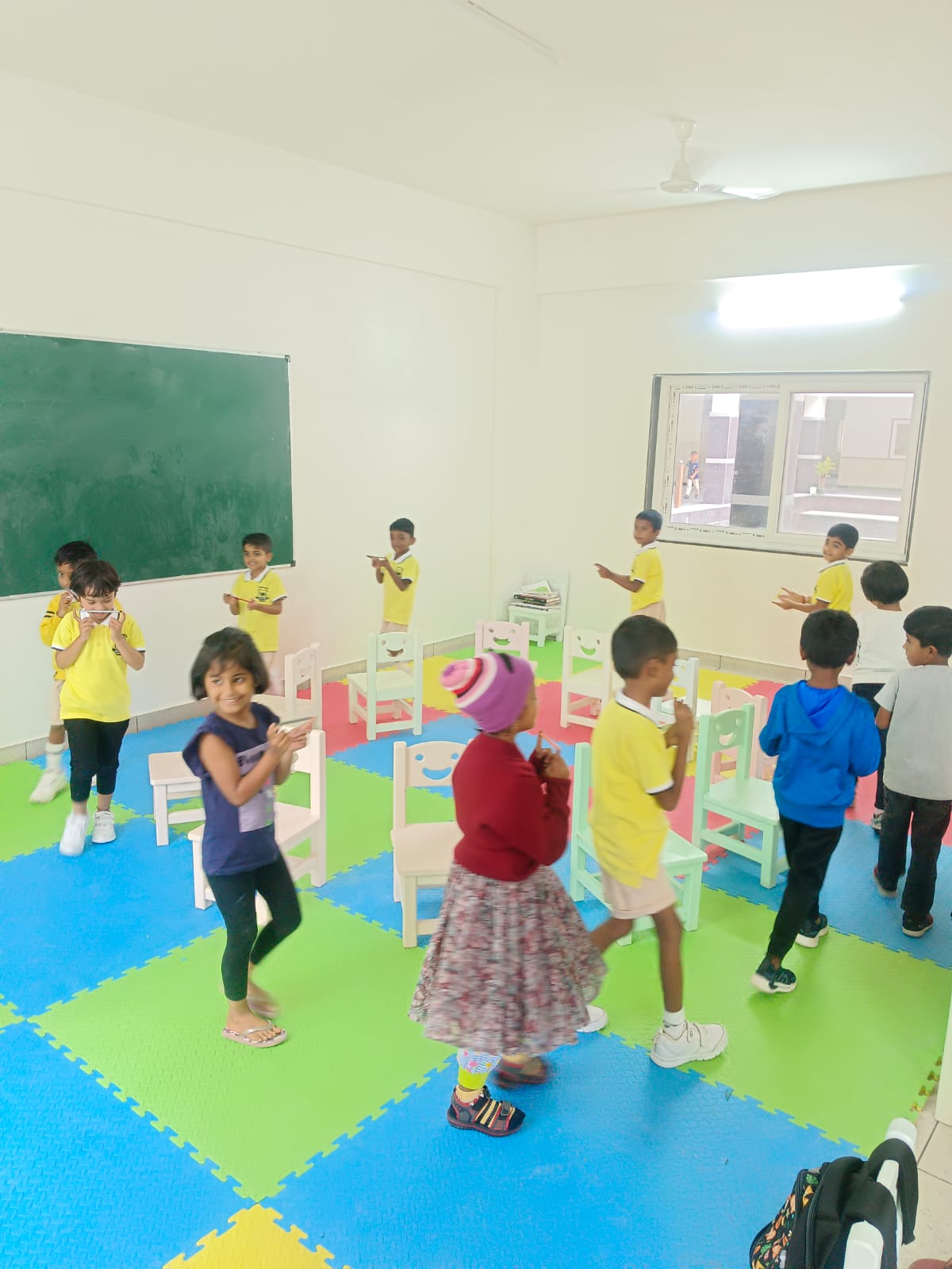 Pre-school children dancing in the activity room at Takshashila School